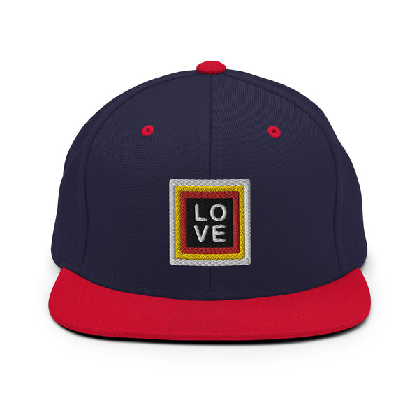 A black snapback hat features an embroidered and original “Love” design by Christian Hat Company - Loves Everywhere
