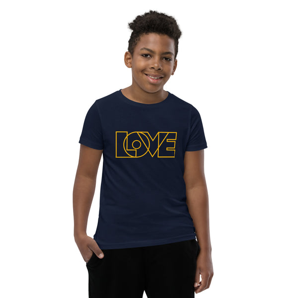 A young man is wearing an original, embroidered Christian T Shirt “Love” design on a Navy Blue short sleeve crew neck shirt by Christian Clothing Brand, Loves Everywhere