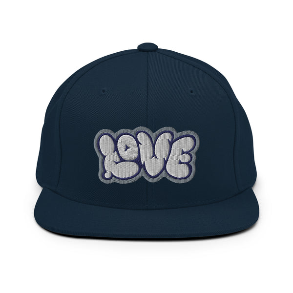 A navy blue snapback hat features an embroidered and original “Love” design by Christian Apparel Company - Loves Everywhere