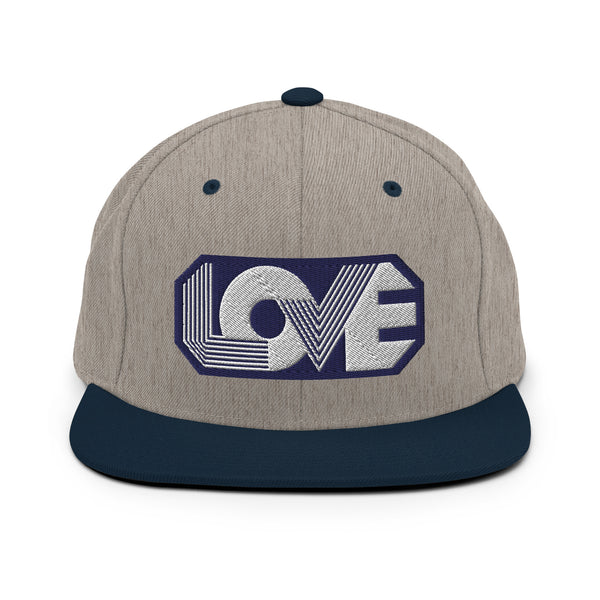 A gray and navy blue snapback hat features an embroidered and original “Love” design by Christian Clothing Brand - Loves Everywhere