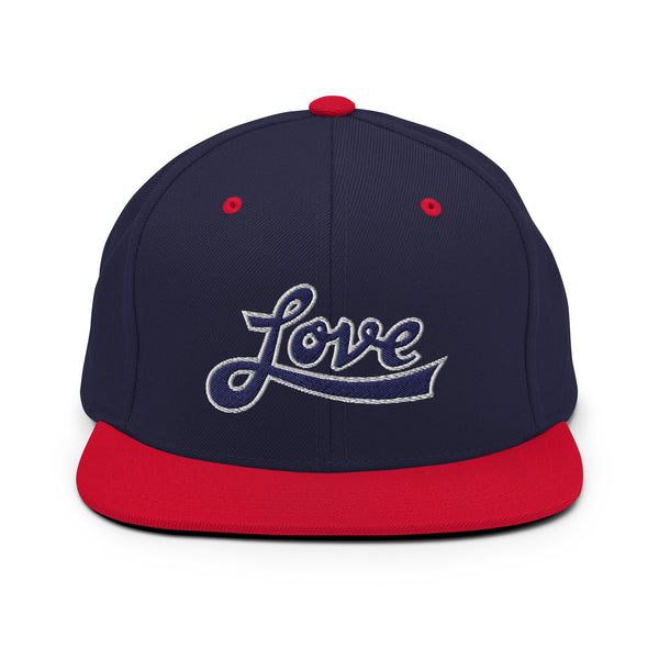 A navy blue and red snapback hat features an embroidered and original “Love” design by Christian Apparel Company - Loves Everywhere