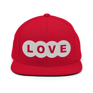 A red snapback hat features an embroidered and original “Love” design by Christian Clothing Brand - Loves Everywhere