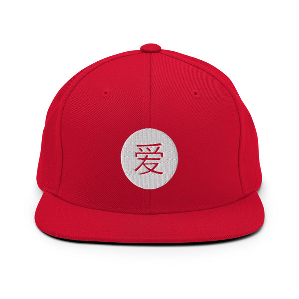 A red snapback hat features an embroidered and original “Love” design by Christian Hat Company - Loves Everywhere