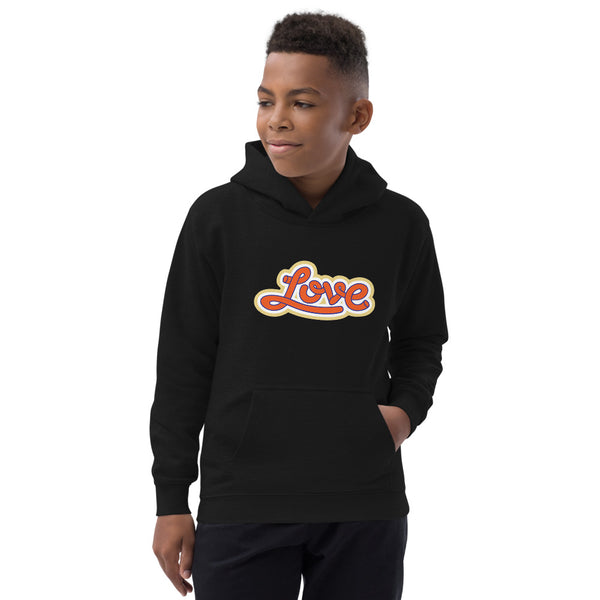 A boy is wearing an original, printed Christian Hoodie featuring a “Love” design on a black hoodie by Christian Apparel Company, Loves Everywhere