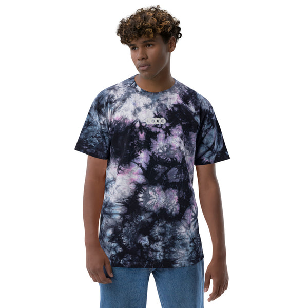 A young man is wearing a blue and white Tie Dye T Shirt for Men featuring an embroidered, original "Love" design by Christian Clothing Brand - Loves Everywhere