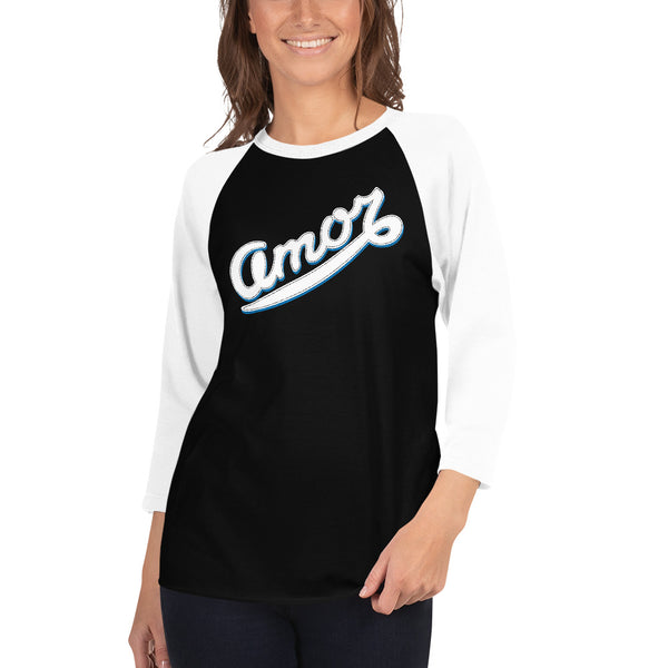 A young woman is wearing a black and white 3/4 Sleeve Raglan T Shirt, featuring an original “Amor” design print by Christian Clothing Brand - Loves Everywhere