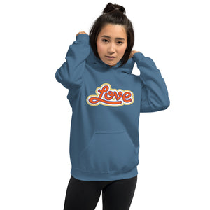 A woman is wearing an Indigo blue hoodie featuring an original “Love” design print by Christian Apparel Line - Loves Everywhere