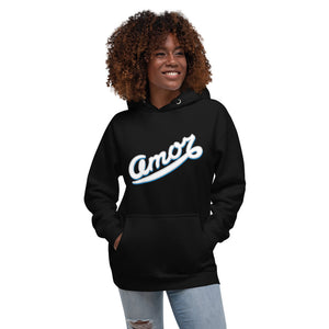 A woman is wearing a black hoodie featuring an original “Amor” design print by Christian Apparel Line - Loves Everywhere