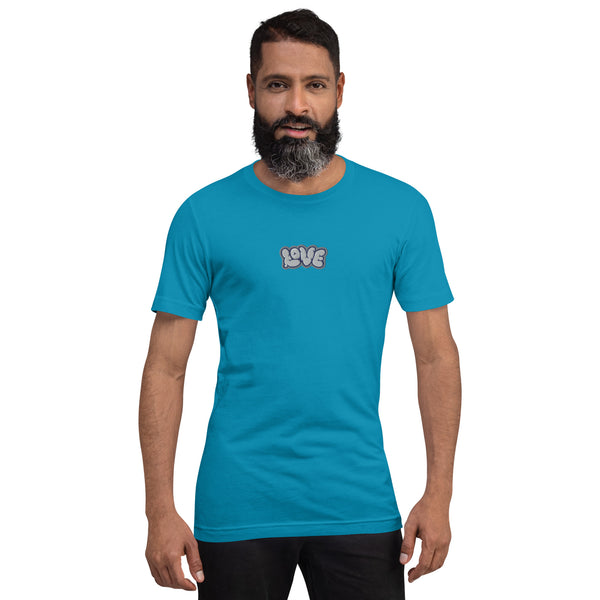 A man is wearing an aqua Short Sleeve T-shirt featuring an embroidered, original “Love” design by Christian Shirt Company - Loves Everywhere