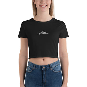 A woman is wearing a black Crop Top T Shirt featuring an embroidered original “Love” design by Christian Clothing Brand - Loves Everywhere