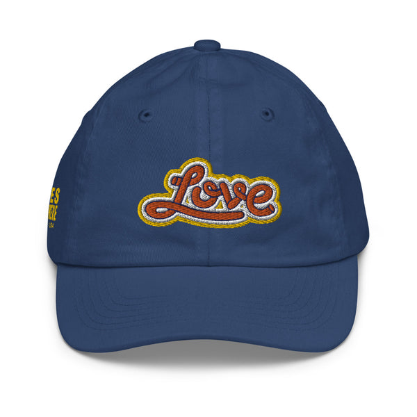 A boy’s navy blue baseball cap featuring an original “Love” design by Christian Hat Company, Loves Everywhere