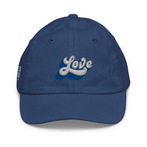 A boy’s navy blue baseball cap featuring an original “Love” design by Christian Hat Company, Loves Everywhere