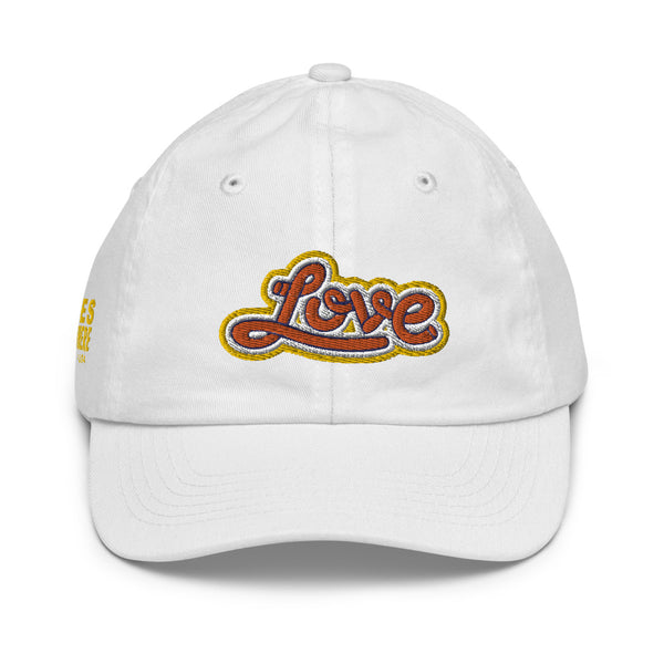 A girl’s white baseball cap featuring an original “Love” design by Christian Clothing Company, Loves Everywhere